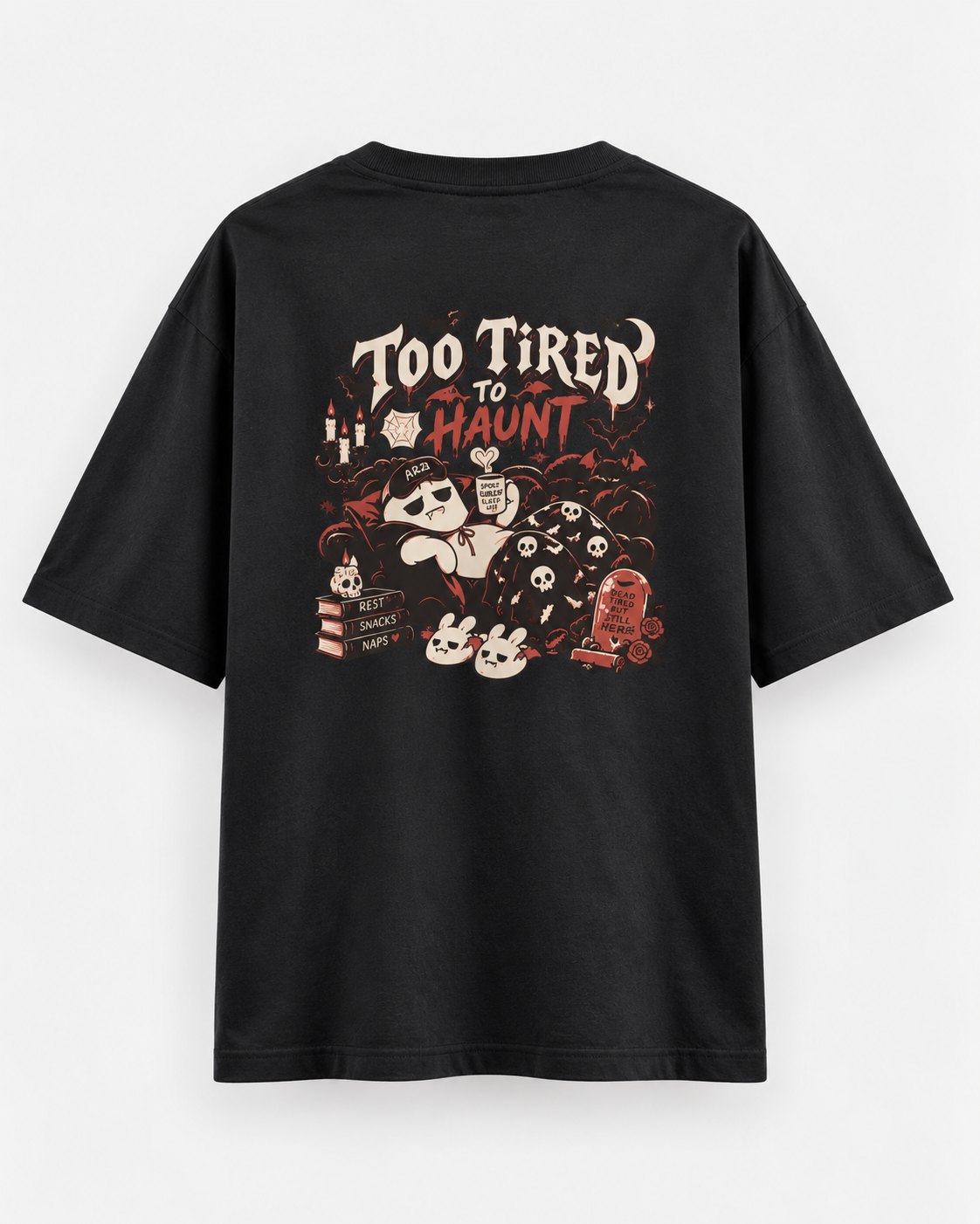 Back of a black oversized Halloween T-shirt featuring “Too Tired to Haunt” lettering, sleepy ghost characters, bats, skulls, candles, and red-and-cream gothic artwork.