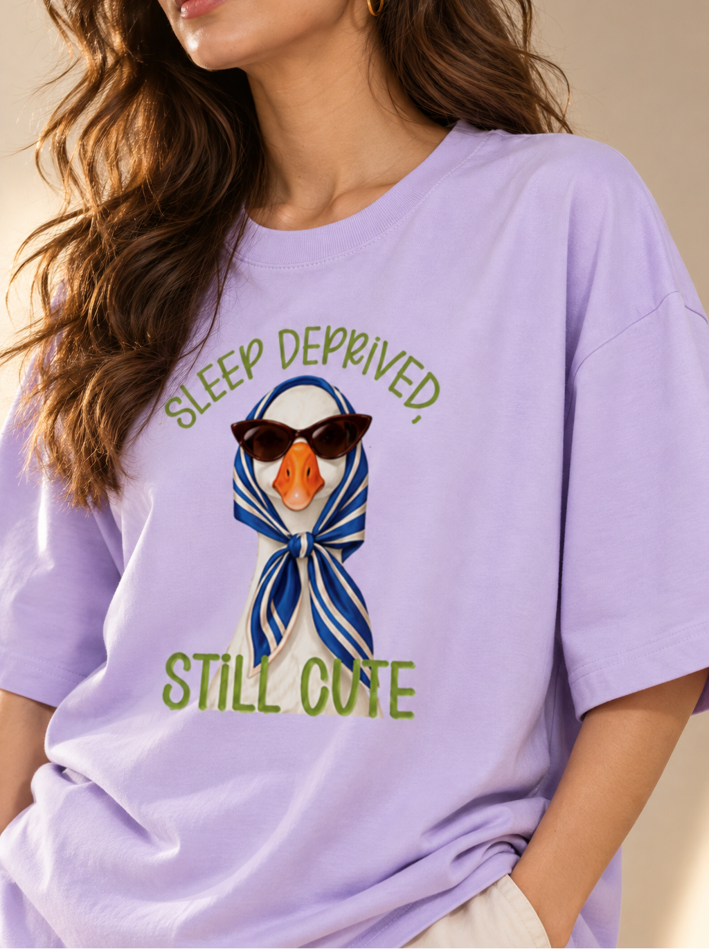 Duck wearing sunglasses and a blue striped headscarf on a lavender tee