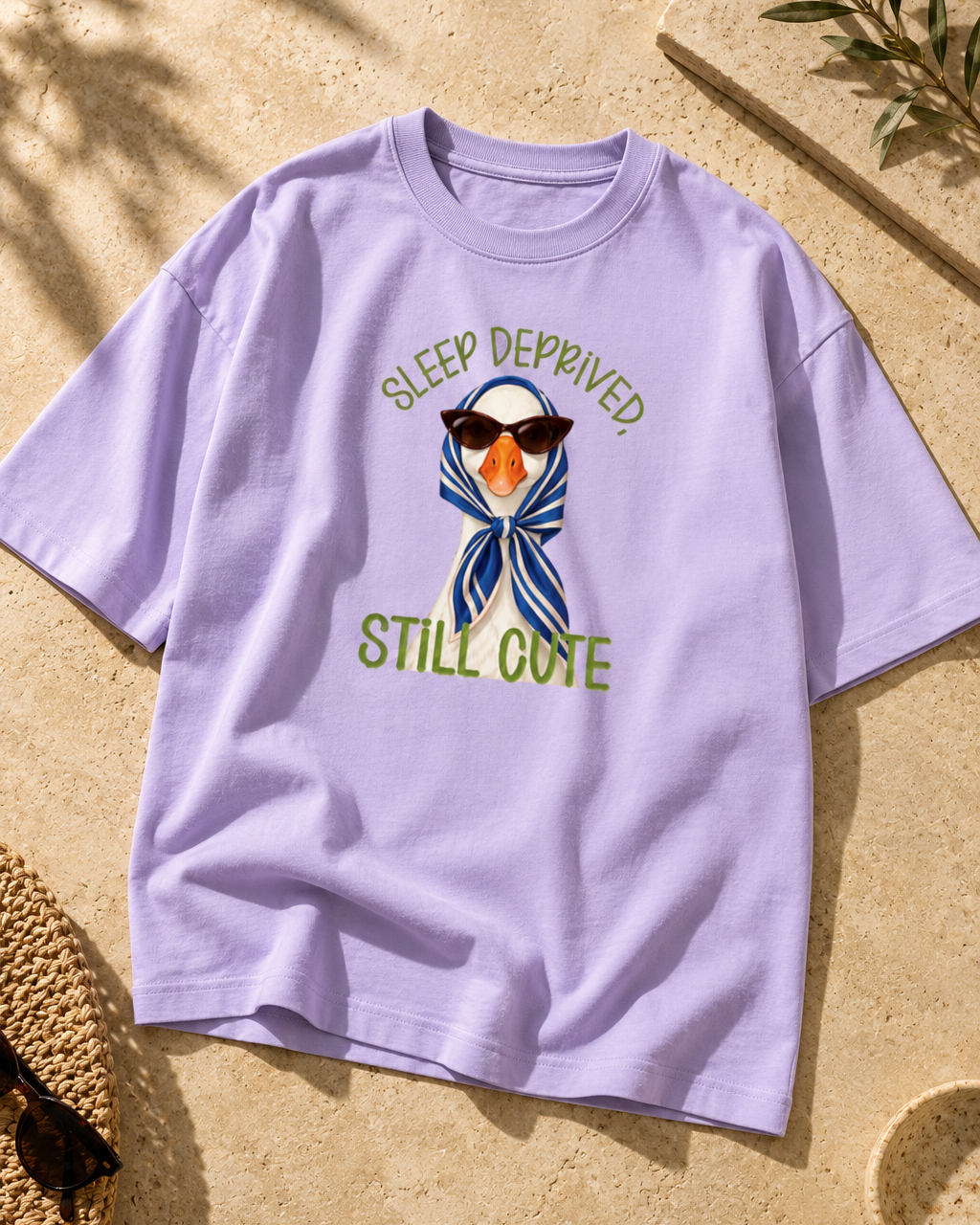 Duck wearing sunglasses and a blue striped headscarf on a lavender tee