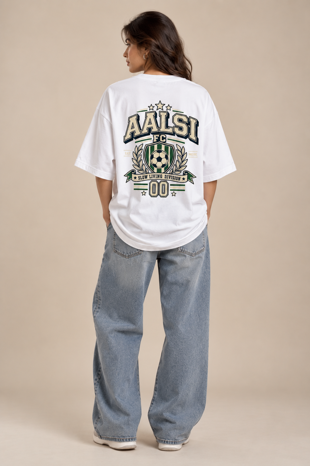 White Aalsi FC oversized T-shirt featuring a large varsity football crest, soccer ball, laurel graphics and Slow Living Division slogan styled with baggy pants.